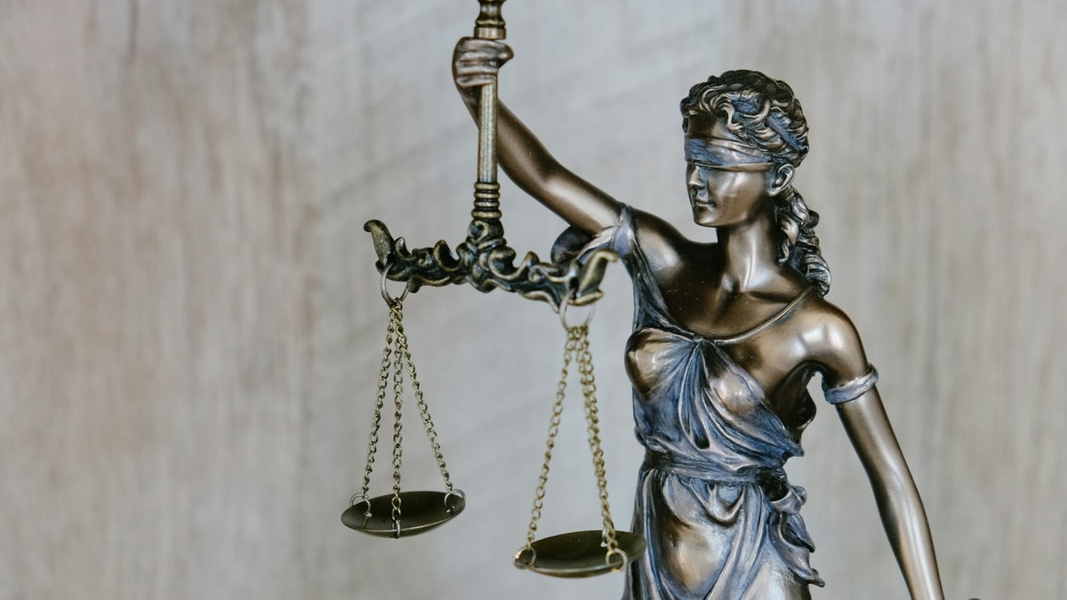 Hukuk kütüphanesinde ahşap adalet tokmağı ve federal kanun ciltleri